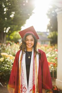 woman in red academic dress wearing red academic hat by Conner Ching courtesy of Unsplash.